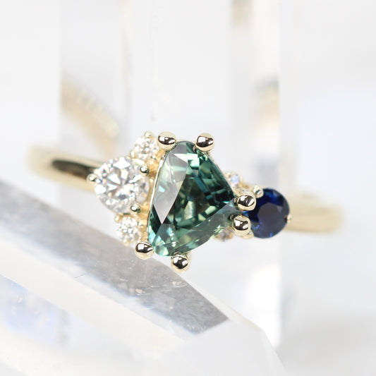 Project: Custom Serena Ring with a 1 Carat Teal Blue Trillion Sapphire and Asymmetrical Accent Diamonds in 14k