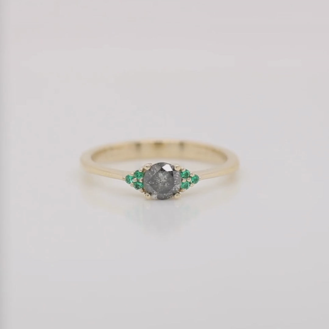 Project: Custom Imogene Ring with a 0.50 Carat Round Dark Gray Black Salt and Pepper Celestial Diamond and Emerald Accents in 14k