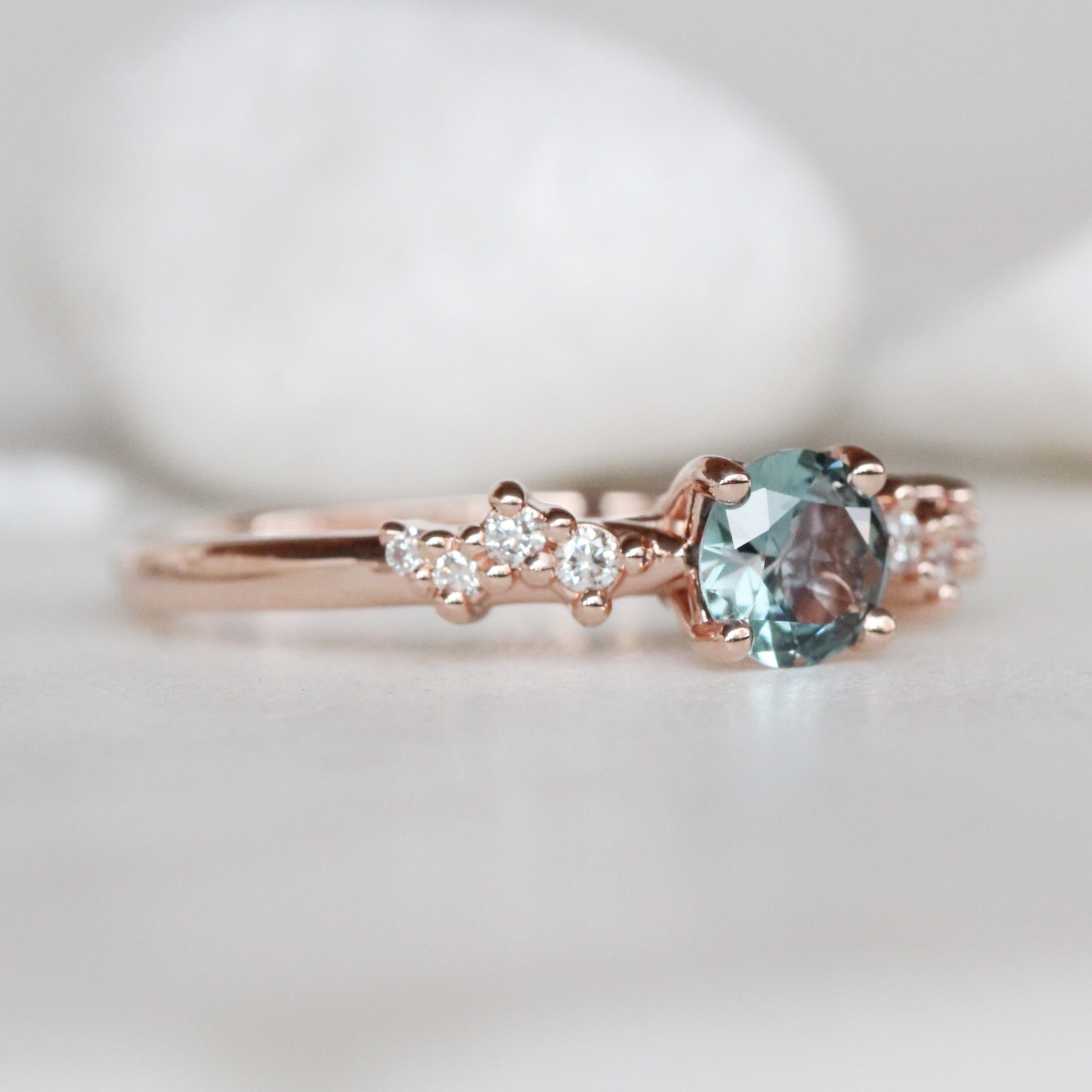 Zealan Ring with a 0.63 Carat Round Teal Sapphire and White Accent Diamonds in 10K Rose Gold - Ready to Size and Ship - Midwinter Co. Alternative Bridal Rings and Modern Fine Jewelry