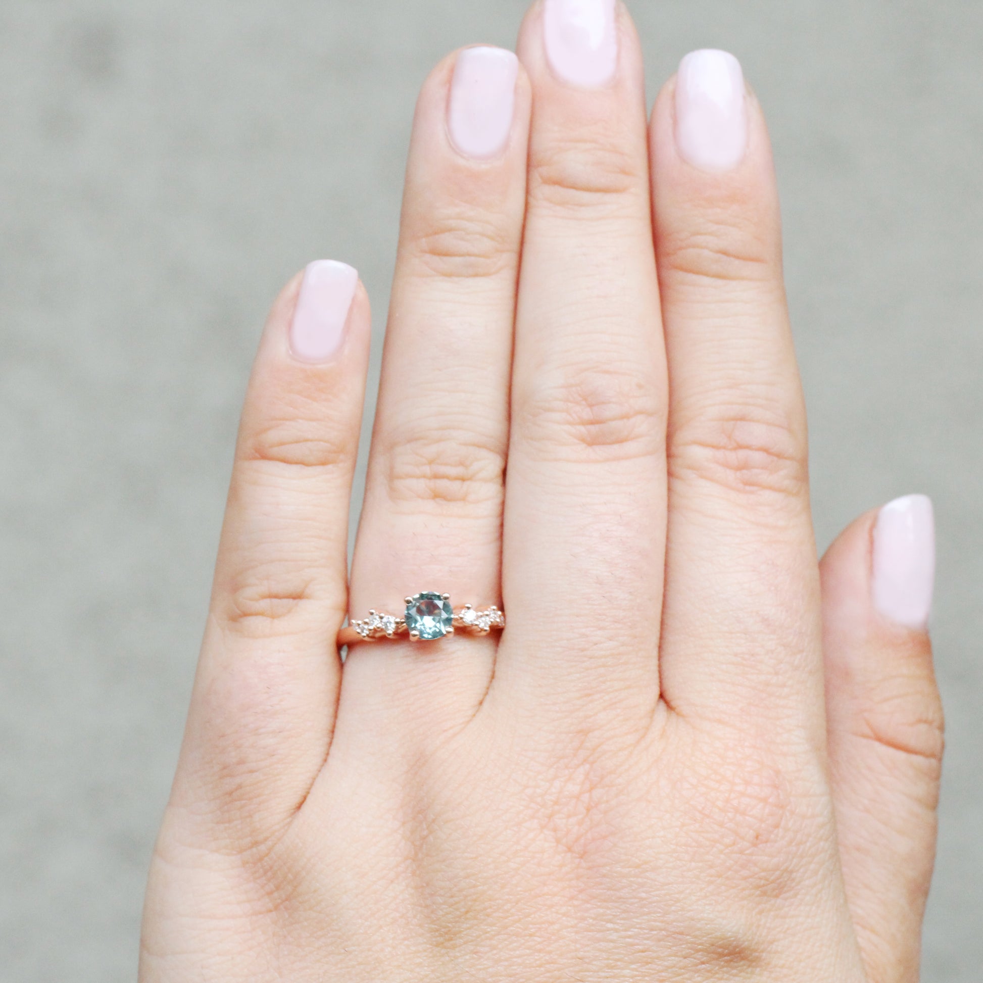 Zealan Ring with a 0.63 Carat Round Teal Sapphire and White Accent Diamonds in 10K Rose Gold - Ready to Size and Ship - Midwinter Co. Alternative Bridal Rings and Modern Fine Jewelry